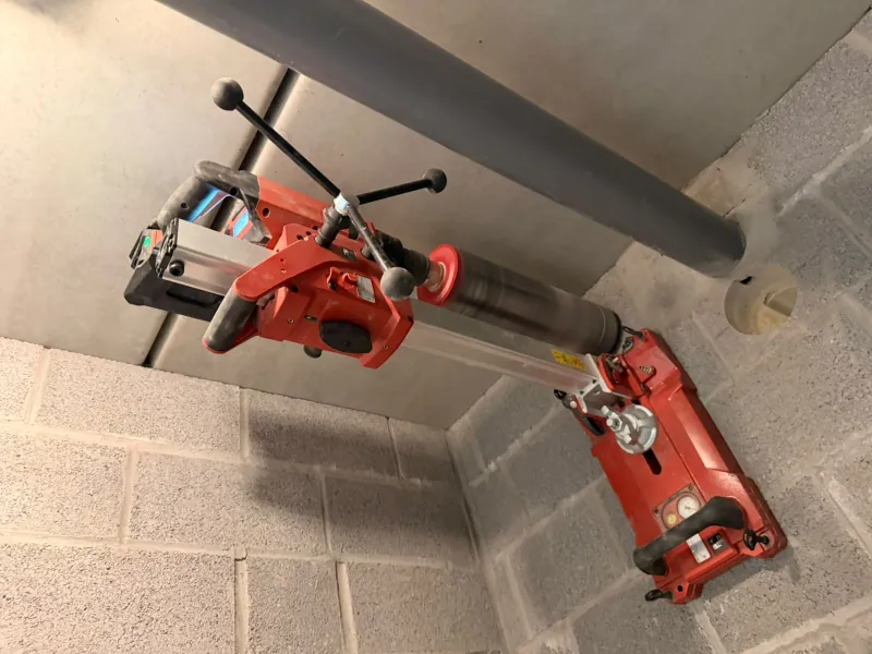 Geboorde doorvoer in een wand van betonblokken voor de ventilatie van de garage