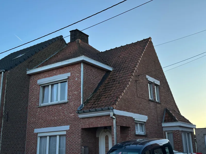 Oud pannendak met mosgroei en versleten pannen, voor de werken